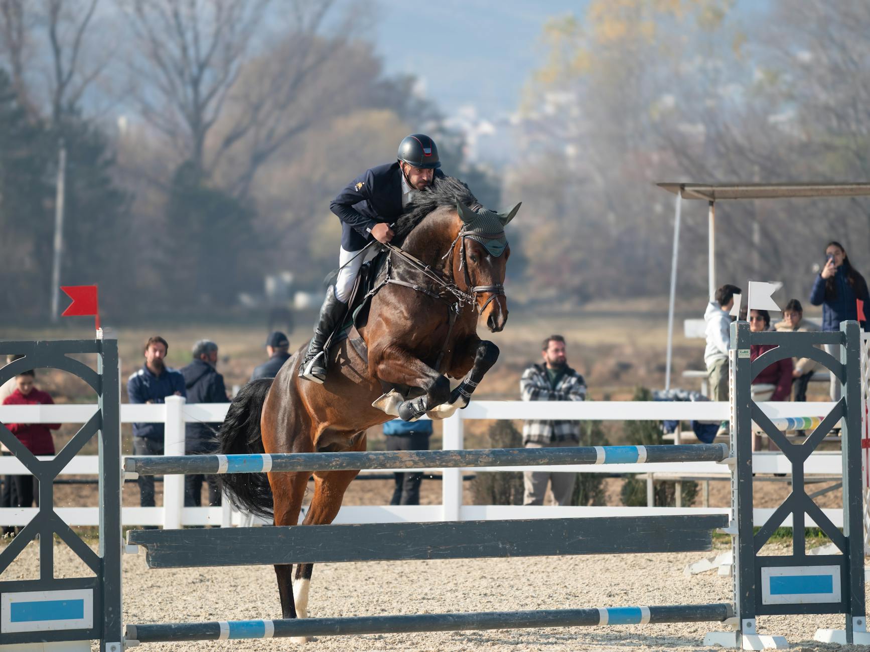 Jeździec pokonuje przeszkodę na parkurze przed publicznością