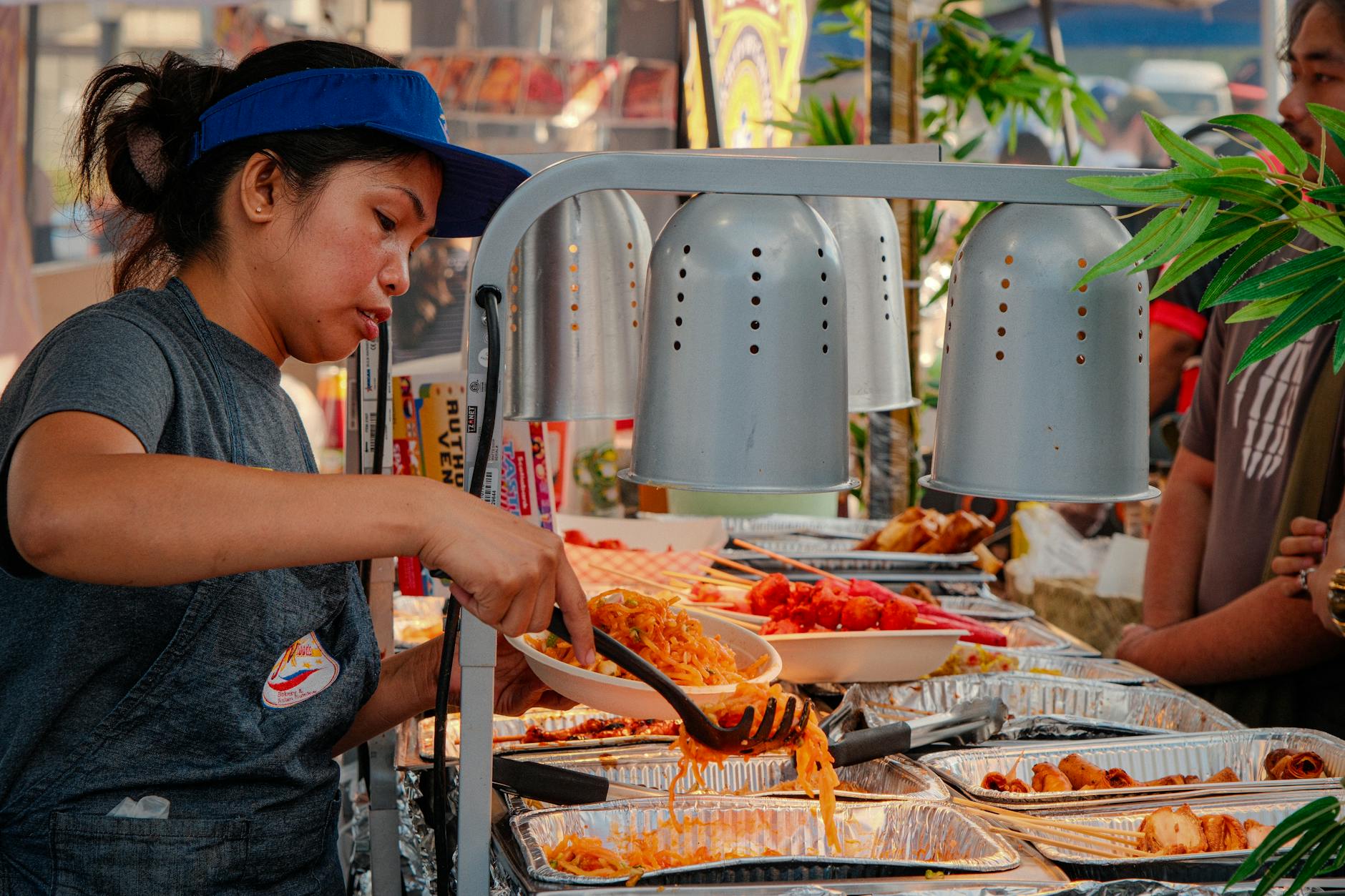 Kobieta podaje kolorowe dania street food na targu w Toronto