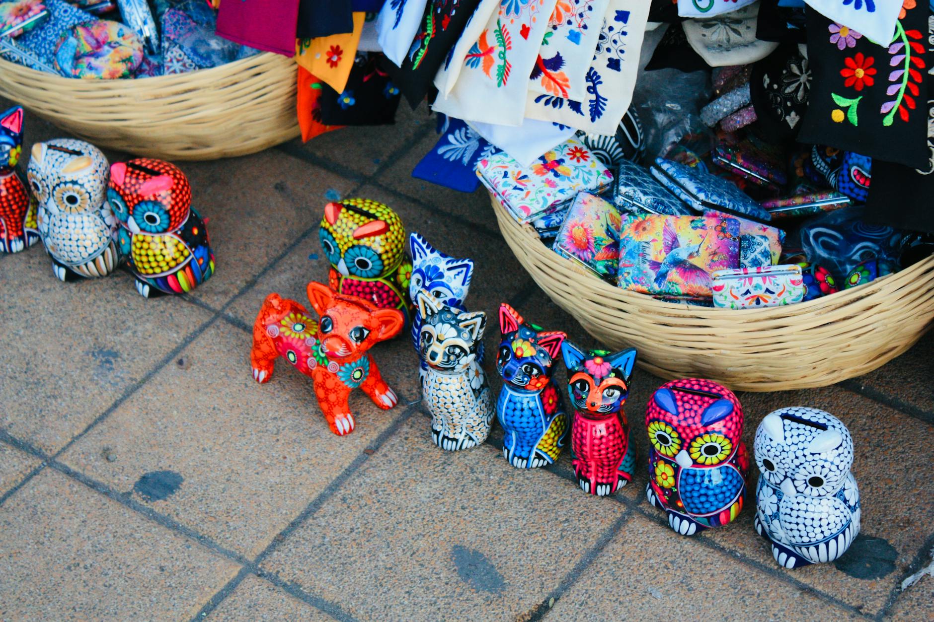 Kolorowe alebrijes i haftowane tkaniny na ulicznym targu w Gwatemali