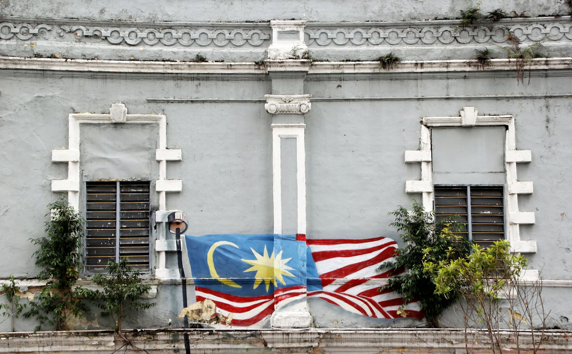 Mur z muralem malezyjskiej flagi na zabytkowej kamienicy w Kuala Lumpur