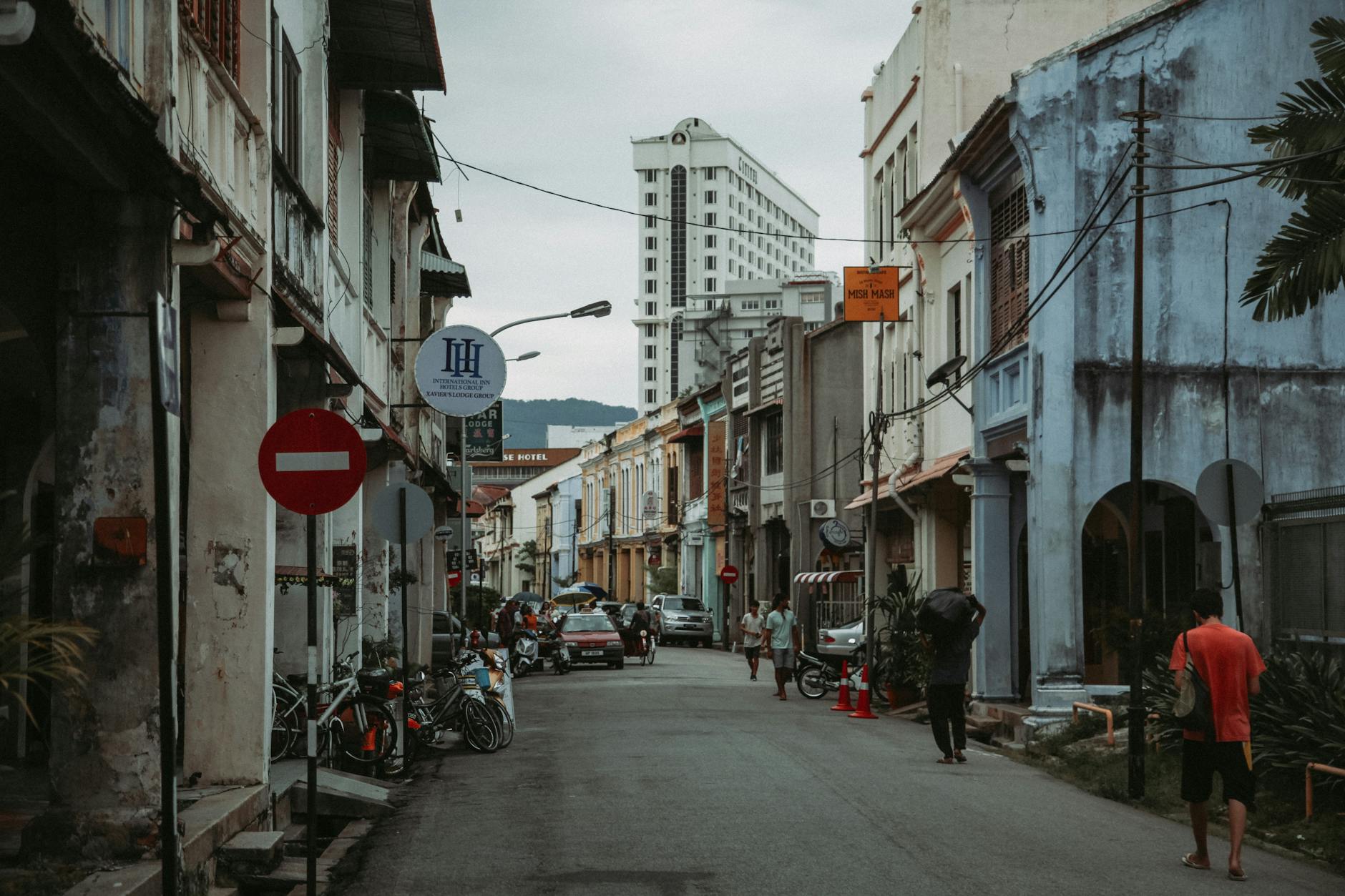 Wąska kolonialna uliczka w Malezji tętniąca życiem przechodniów