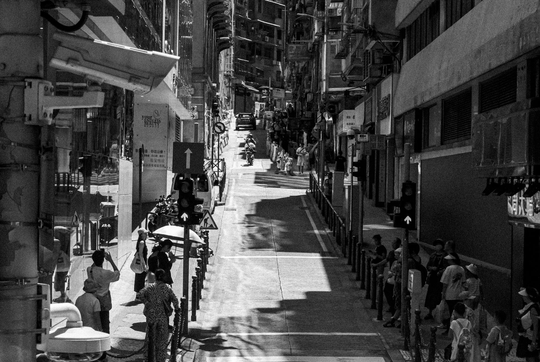 Czarno-biała ulica Makau z pieszymi i sklepami