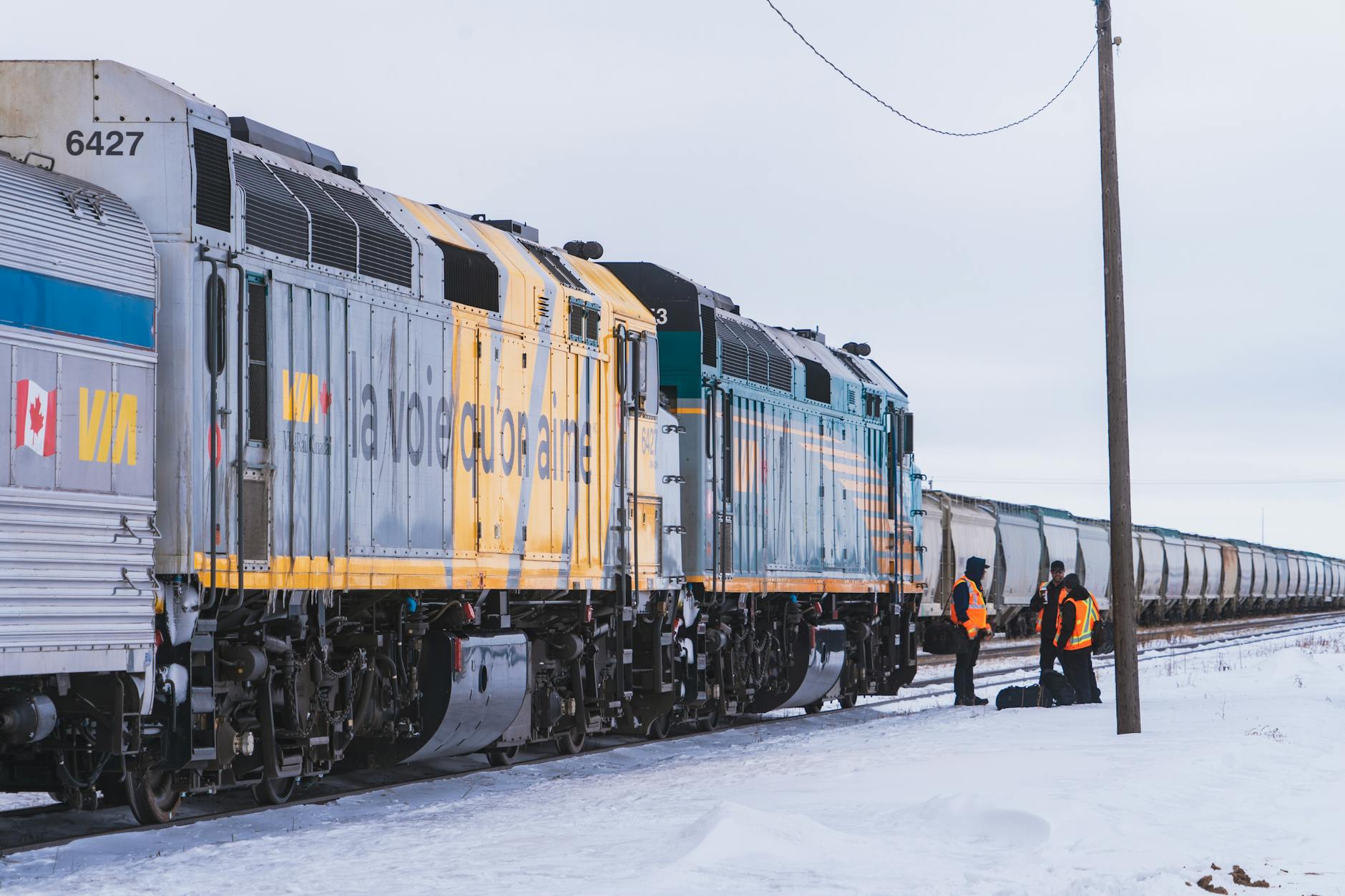 Pociąg VIA Rail zimą na zaśnieżonym polu w Kanadzie i pracownicy torów