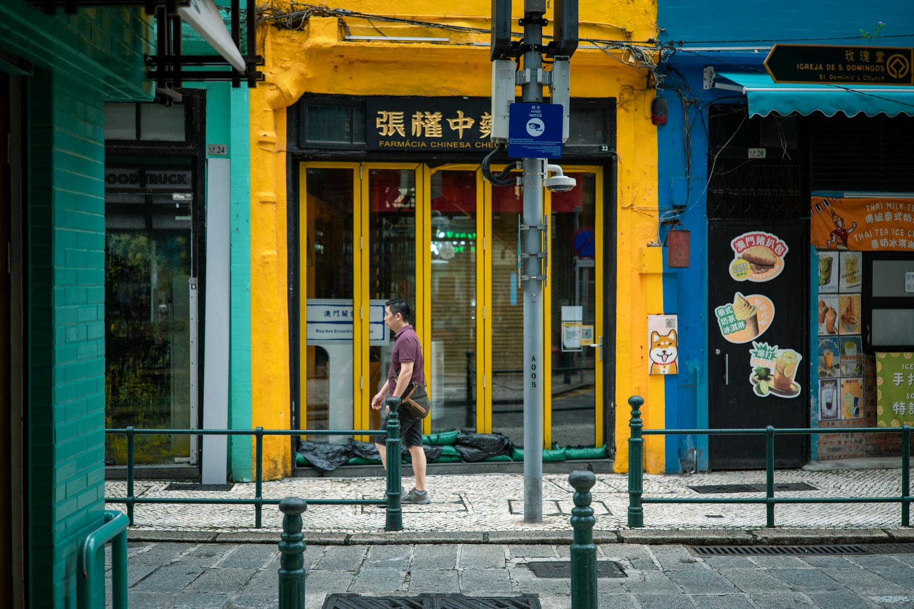 Przechodzień mija kolorowy sklep na ulicy w Makau
