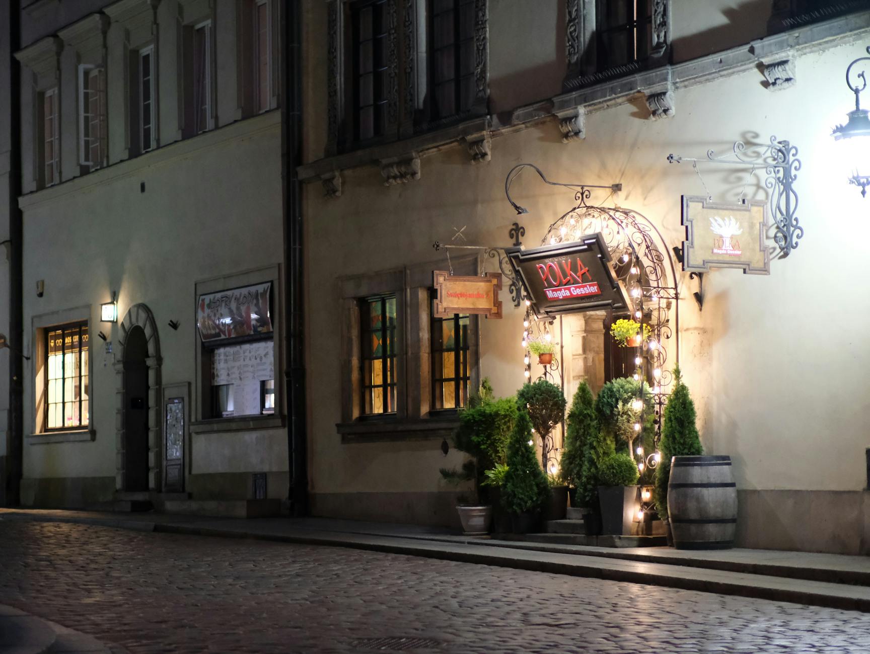 Wieczorne wejście do przytulnej restauracji przy brukowanej uliczce